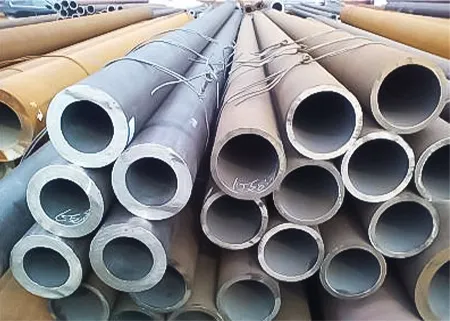 Stacks of carbon steel pipes arranged neatly, showcasing different diameters and lengths.