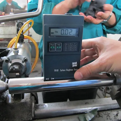 A surface roughness tester being used to measure the smoothness of a metal bar.