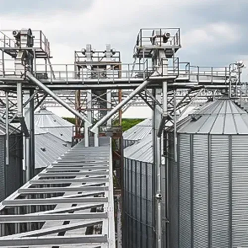 Large industrial dryer system with metal silos and structural walkways in an open industrial setup.