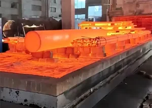 Red-hot 4140 steel undergoing heat treatment process in an industrial furnace.