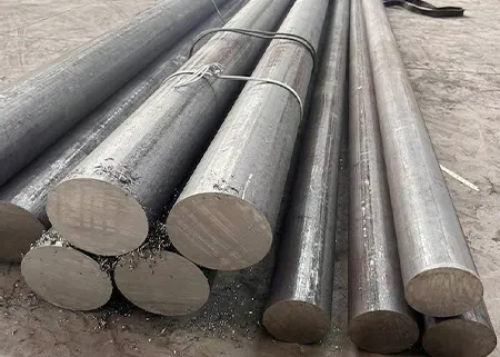 Bundled Inconel alloy round bars stacked on a workshop floor.
