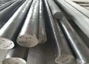 Monel 400 round bars marked with specifications, stacked in a workshop.